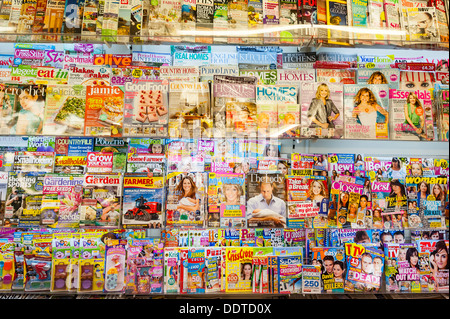 Riviste per la vendita su un ripiano in un'edicola shop store del Regno Unito Foto Stock