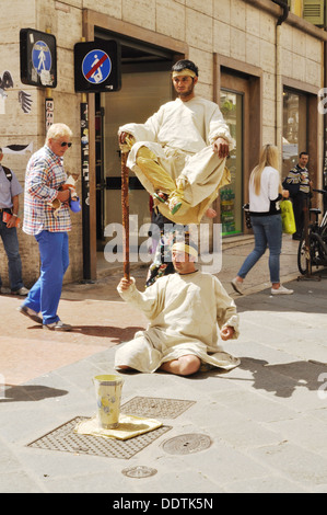 Due gli artisti di strada di eseguire un apparentemente impossibile feat a Verona. Foto Stock