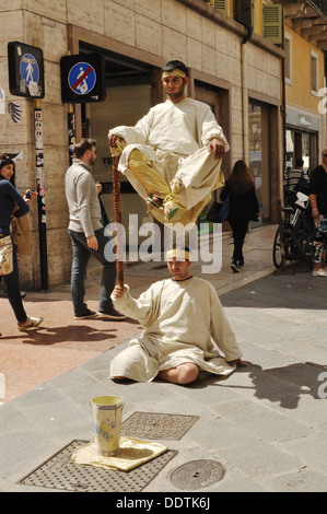 Due gli artisti di strada di eseguire un apparentemente impossibile feat a Verona. Foto Stock