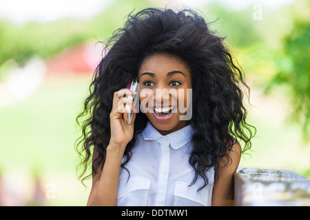 Outdoor ritratto di un adolescente ragazza nero utilizzando un telefono cellulare - popolo africano Foto Stock