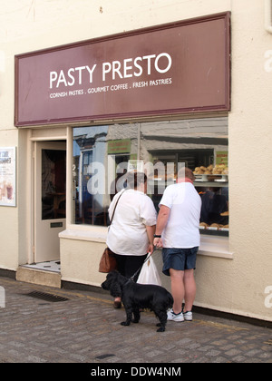 Il sovrappeso giovane guardando nella vetrina di un negozio di pastoso, Cornwall, Regno Unito 2013 Foto Stock