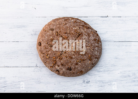 Home cotto il pane integrale su bianco tavola di legno Foto Stock