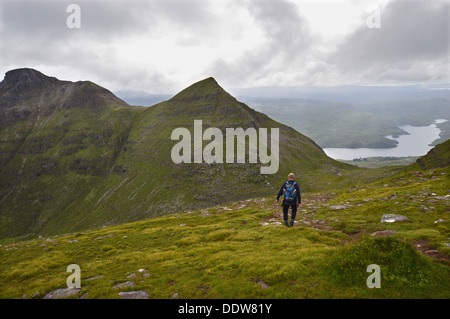 Lone walker maschio sulla cresta occidentale di vela Gharbh (a) Corbett sulla montagna scozzese Quinag dirigendosi verso Spidean Coinich Foto Stock