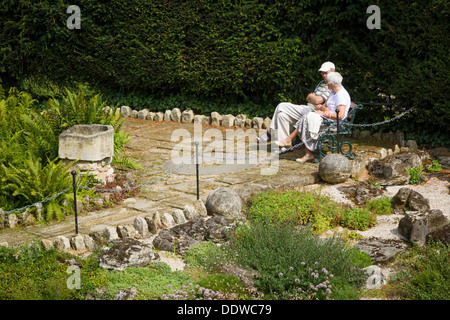 Coppia di anziani sat relax su una panca in Brodsworth Hall Gardens, Doncaster, South Yorkshire. Foto Stock
