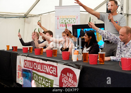 Come parte di Kingston Food Festival, i concorrenti la linea fino a prendere parte alla sfida di peperoncino, i partecipanti iniziano a subire. Foto Stock