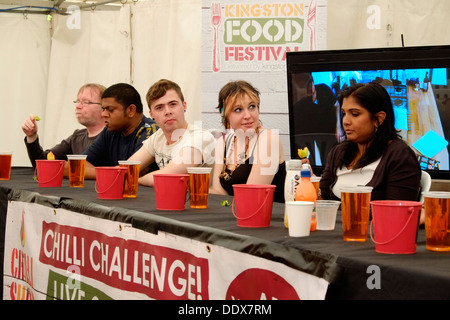 Come parte di Kingston Food Festival, i concorrenti la linea fino a prendere parte alla sfida di peperoncino, i partecipanti iniziano a subire. Foto Stock