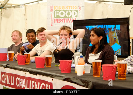 Come parte di Kingston Food Festival, i concorrenti la linea fino a prendere parte alla sfida di peperoncino, i partecipanti iniziano a subire. Foto Stock