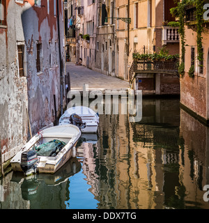 Tipico canale veneziano con gli edifici storici si riflette nell'acqua Foto Stock