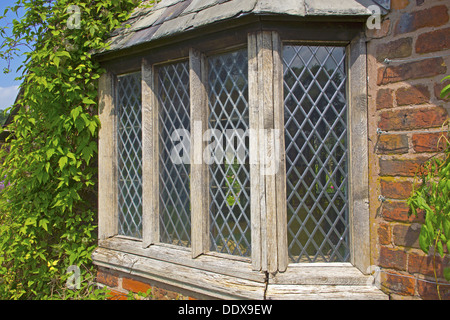 Vecchia finestra spiovente di una casa con giardino con vetro piombato riquadri. Foto Stock