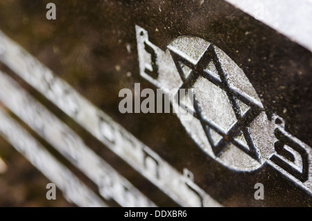 Le lapidi in un cimitero ebraico scritta in ebraico con una stella di Davide Foto Stock