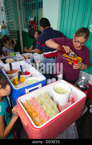 Una donna vende ghiaccioli per bambini in un food festival nella città di Puebla, Messico Foto Stock