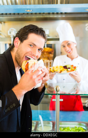 Döner Kebab - Gentile fornitore e cliente in un bagno turco di fast food eatery, con una fresca fatta pane pita Foto Stock