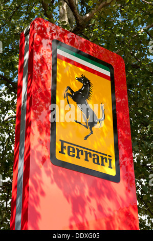 Un segno della Ferrari si erge al di fuori di un dealdership a Lyndhurst in New Forest National Park in Hampshire (solo uso editoriale). Foto Stock