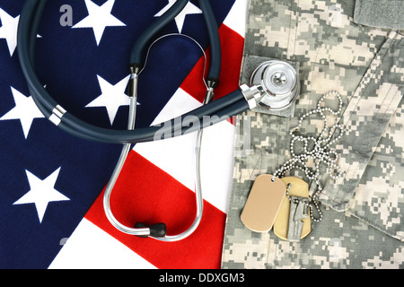 Militari di fatiche e dog tag su una bandiera americana con uno stetoscopio per illustrare la salute nelle forze armate. Foto Stock