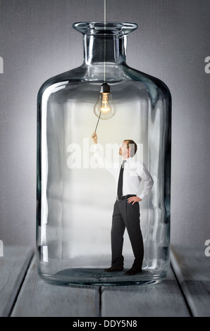 L uomo sta in una bottiglia e si accende la spia Foto Stock