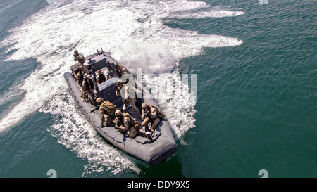 Stati Uniti Marines assegnato a forza di plotone di ricognizione marittima forza Raid, 26 Marine Expeditionary Unit forniscono la protezione quando si avvicinano a una nave durante il training Agosto 28, 2013 in Bahrein. Foto Stock