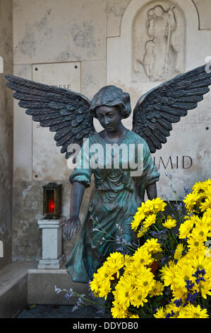 Tomba di famiglia con angelo candela votiva e fiori sul Ostfriedhof o est cimitero, Monaco di Baviera Foto Stock