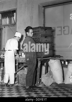 Ragazzo delle consegne di prelevare le scatole di pane al Lisa Öhman panificio, Stoccolma, Svezia, 10 ottobre 1942. Artista: Karl Sandels Foto Stock