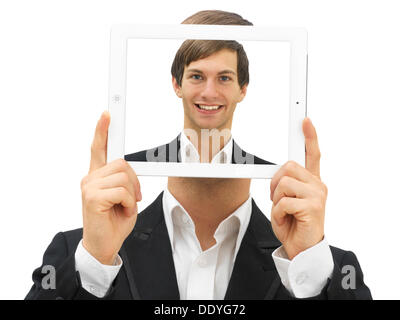 Imprenditore in possesso di un iPad con un autoritratto di fronte il suo volto Foto Stock