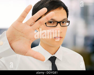 Giovane imprenditore, Asiatica, con occhiali, tenendo la mano davanti al volto, abrasivo, grave, ha sottolineato Foto Stock