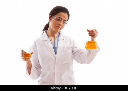 Giovane donna scienziato holding becher e matracci riempito con liquido giallo isolato su sfondo bianco Foto Stock