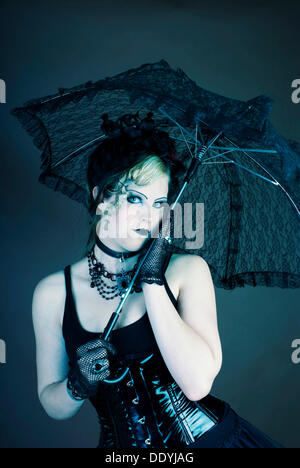 Donna, gotico, serio, parasol e lucida corsetto Foto Stock
