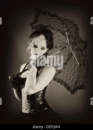 Donna, gotico, dai capelli scuri, ombrellone e lucida corsetto Foto Stock