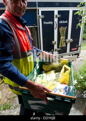 Tesco dipendente van driver con un negozio di generi alimentari nella casella consegna ordinati online e consegnato alla casa in zone rurali del Galles UK KATHY DEWITT Foto Stock