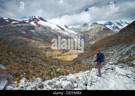 Femmina di escursionisti a piedi nei Huascarán National Park, Ande peruviane con Huascara Yanapaccha e nella distanza. Foto Stock