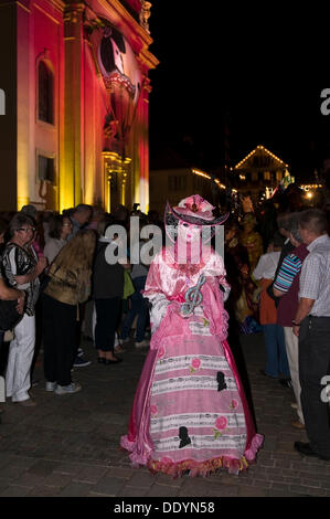 Sfilata di maschere indossatori di fronte alla storica chiesa comunale veneziano, equo, sulla storica Marktplatz piazza del mercato Foto Stock