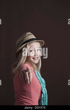 Sorridente ragazza adolescente indossando un cappello rivolto verso la telecamera Foto Stock