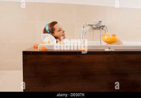 Lettura di una donna in una vasca da bagno Foto Stock