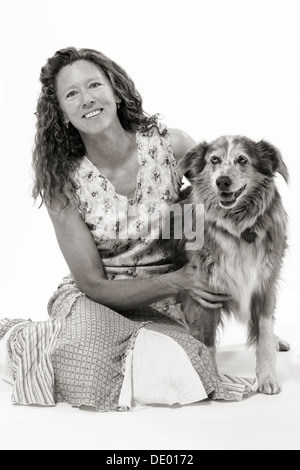 Black & White studio fotografia di donna attraente in abiti estivi con il suo cane, Miss Kitty, un pastore australiano mix Foto Stock