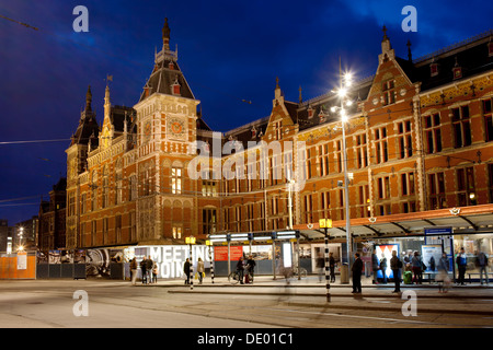 Amsterdam Stazione Centrale e la fermata del tram di notte in Olanda, Paesi Bassi. Foto Stock