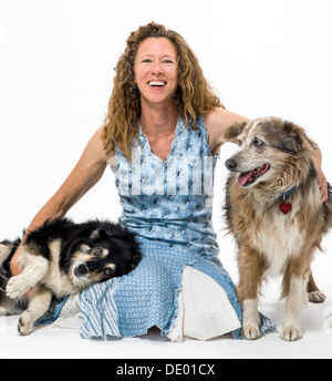 Studio fotografico di donna attraente con due cani, un Border Collie mix e Australian Shepherd mix Foto Stock