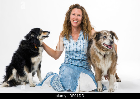 Studio fotografico di donna attraente con due cani, un Border Collie mix e Australian Shepherd mix Foto Stock