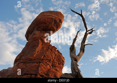 Roccia equilibrato in piedi nel Parco Nazionale di Arches sotto nuvole bianche in Utah Foto Stock