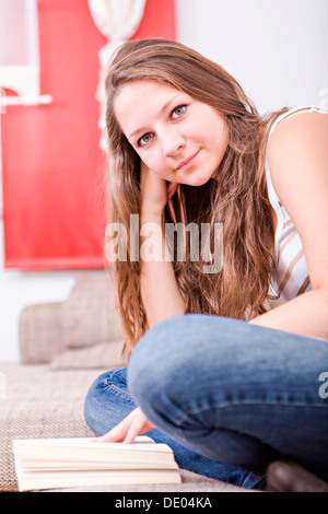 Ragazza la lettura di un libro a casa Foto Stock