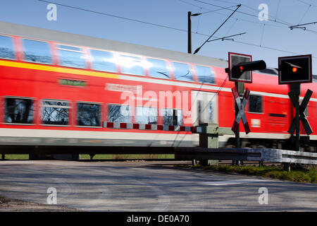 Incrocio ferroviario con treno passare Foto Stock