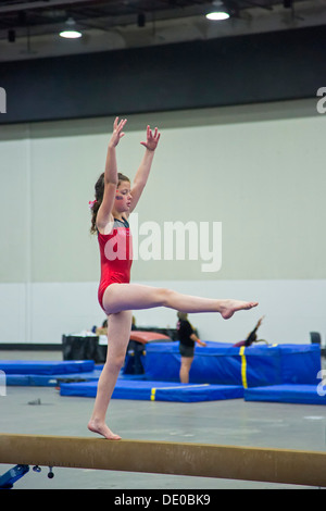 Detroit, Michigan - una ragazza compete sul fascio di equilibrio durante l'AAU Junior Giochi Olimpici. Foto Stock