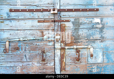 Ferro vecchio arrugginito, fermo sulla vecchia porta di legno Foto Stock