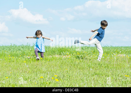 I bambini in esecuzione in campo con armi fuori Foto Stock