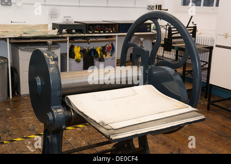 Un vecchio mano guidata pressa a rulli in un college workshop Foto Stock