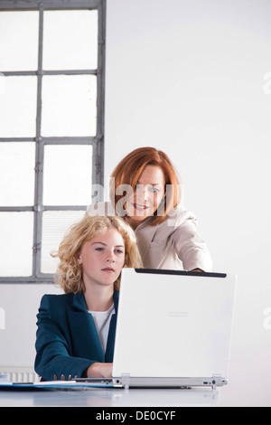 Manager che lavora in un ufficio con un tirocinante presso il computer Foto Stock