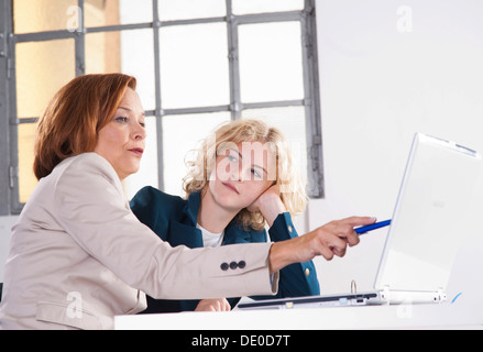 Manager che lavora in un ufficio con un tirocinante presso il computer Foto Stock