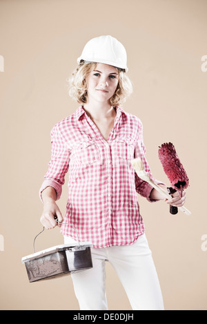 Ragazza vestita come un pittore che indossa un elmetto Foto Stock