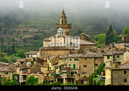 Vista del villaggio con pioggia nuvole, davanti alla chiesa parrocchiale di Sant Bartomeu, Valldemossa, regione Comarca Serra de Tramuntana Foto Stock