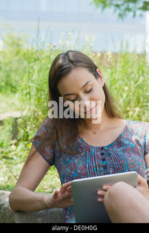 Donna con tavoletta digitale all'aperto Foto Stock