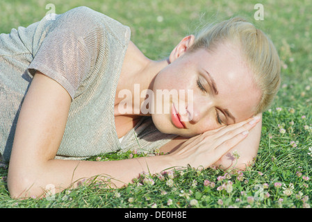 Giovane donna napping sull'erba Foto Stock