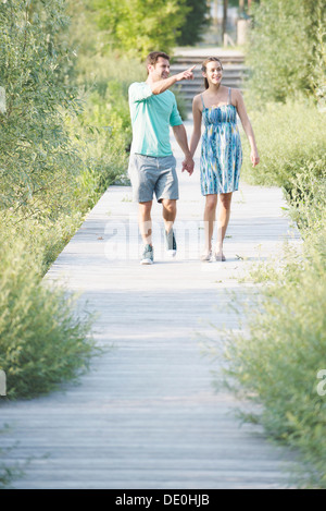 Giovane holding hands godendo di camminare lungo la passeggiata attraverso la natura preservare Foto Stock